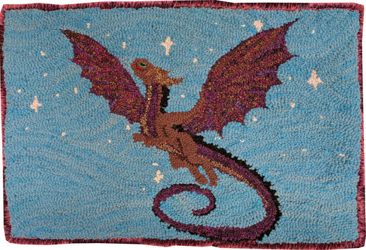 “Sparkle Dragon” – hand-hooked rug by Carmen Hall depicting a glittering dragon in flight against a blue starry sky, made from sparkle fabric.

