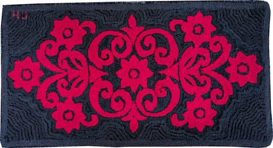 “Wrought Iron Red” – hand-hooked rug by Carmen Hall featuring bold crimson floral scrollwork on a black background, made from fleece and velour.


