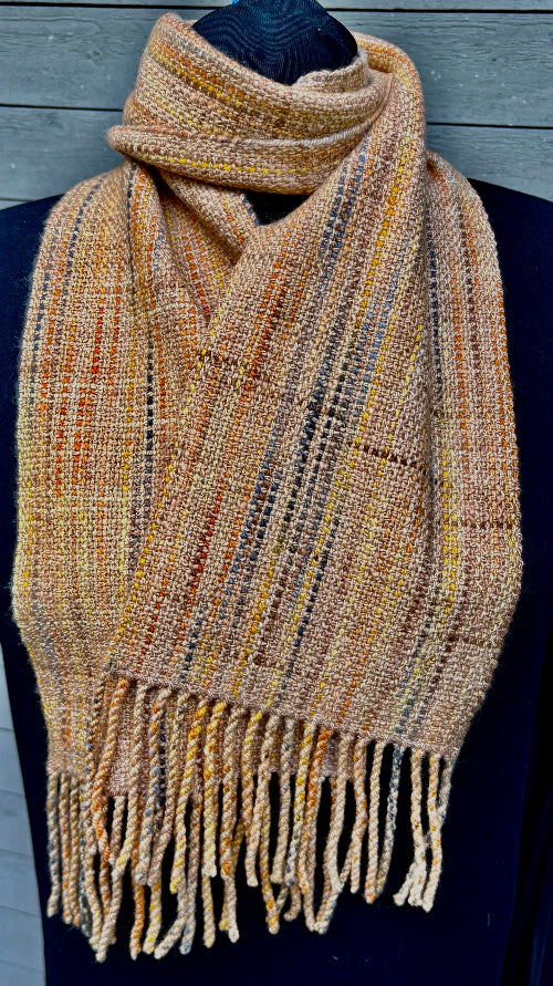 Variegated orange and rust merino wool scarf, handspun, hand-dyed, and handwoven by Vyvyan Dorsett, with fringe